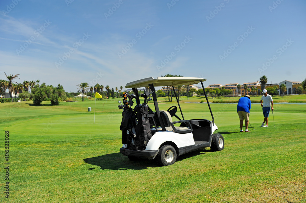 Golfers and buggy in Costa Ballena Golf course, Rota, Cadiz province, Spain