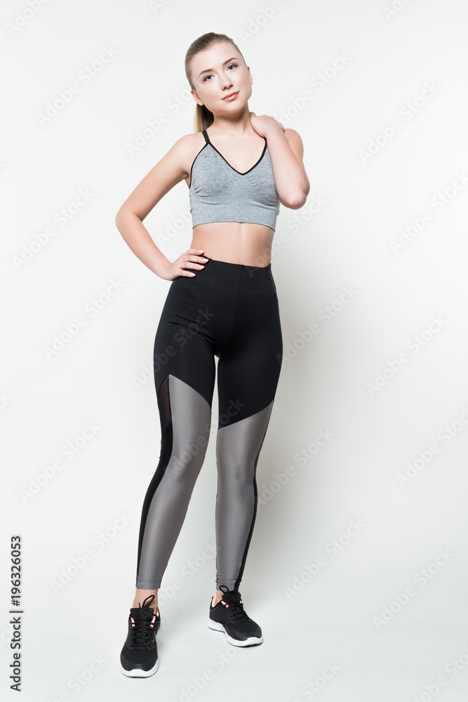 Attractive woman in sports clothes posing isolated on white Attractive woman in sports clothes posing isolated on white