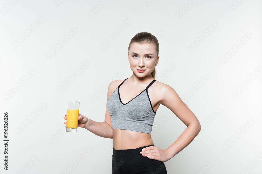 Fit girl holding glass with juice isolated on white Fit girl holding glass with juice isolated on white