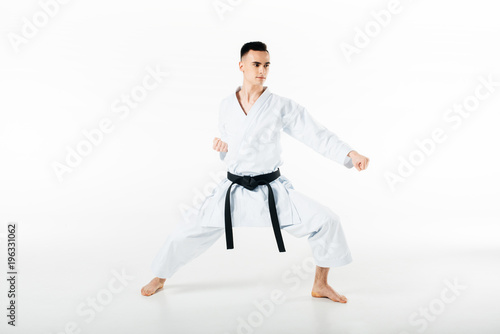 Male karate fighter training isolated on white