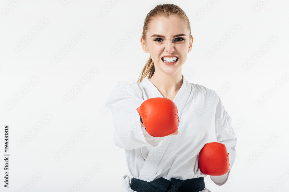 female karate fighter exercising with gloves and mouthguard isolated on white female karate fighter exercising with gloves and mouthguard isolated on white