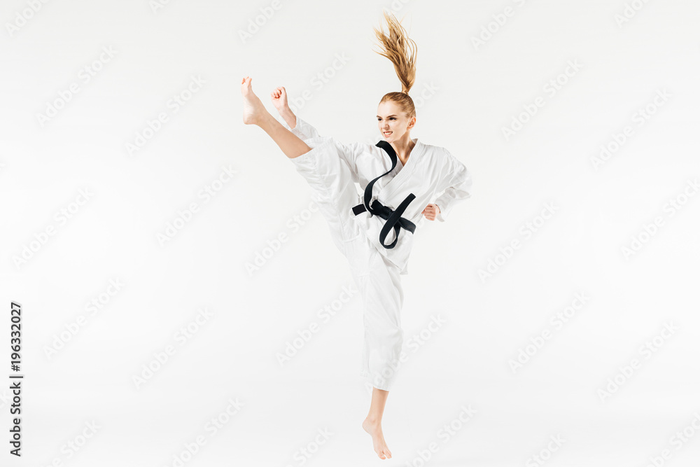 female karate fighter performing kick isolated on white female karate fighter performing kick isolated on white