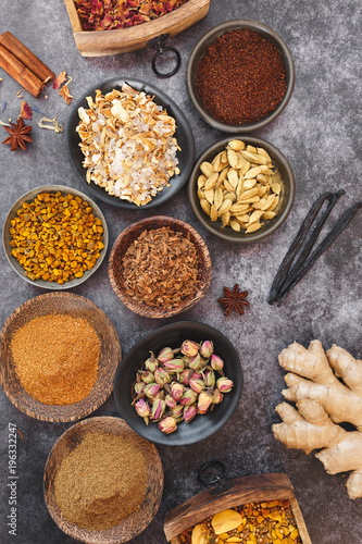 Collection of dried spices in whole and powder form and curry mixtures on dark  background, top view