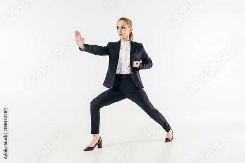 businesswoman exercising karate in suit isolated on white