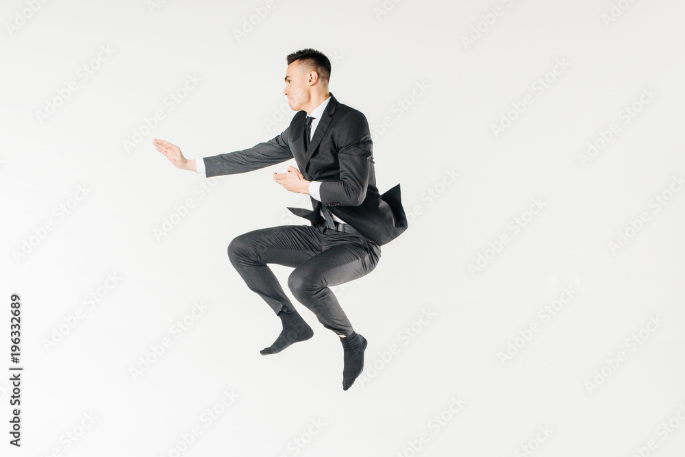 male karate fighter jumping in suit isolated on white