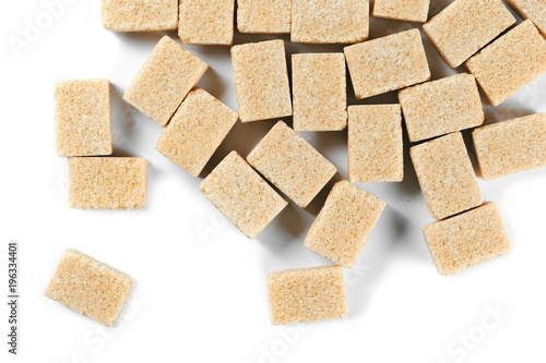 pile brown cane sugar cubes isolated on white background, top view