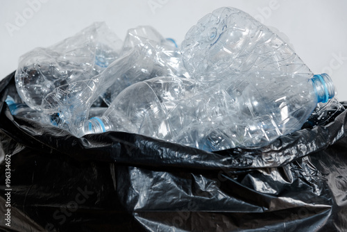 Plastic bottles in black garbage bags waiting to be taken to recycle.