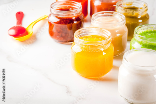Variety of homemade baby vegetable and fruit puree,  white marble background copy space