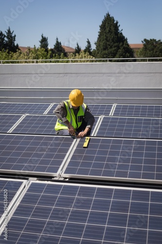 Male worker working on solar panels at solar station