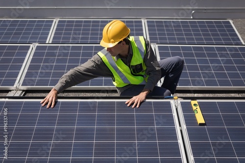 Male worker working on solar panels at solar station photo