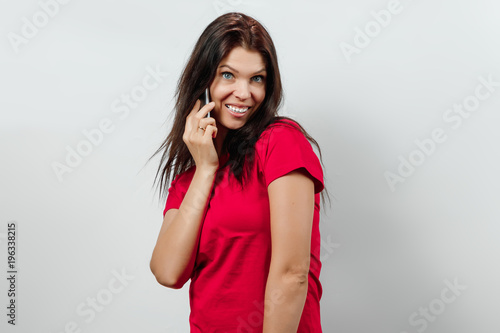 Young, beautiful girl having fun on the phone. Isolated on a light background. Different human emotions, feelings of facial expression, attitude, perception, body language, reaction.