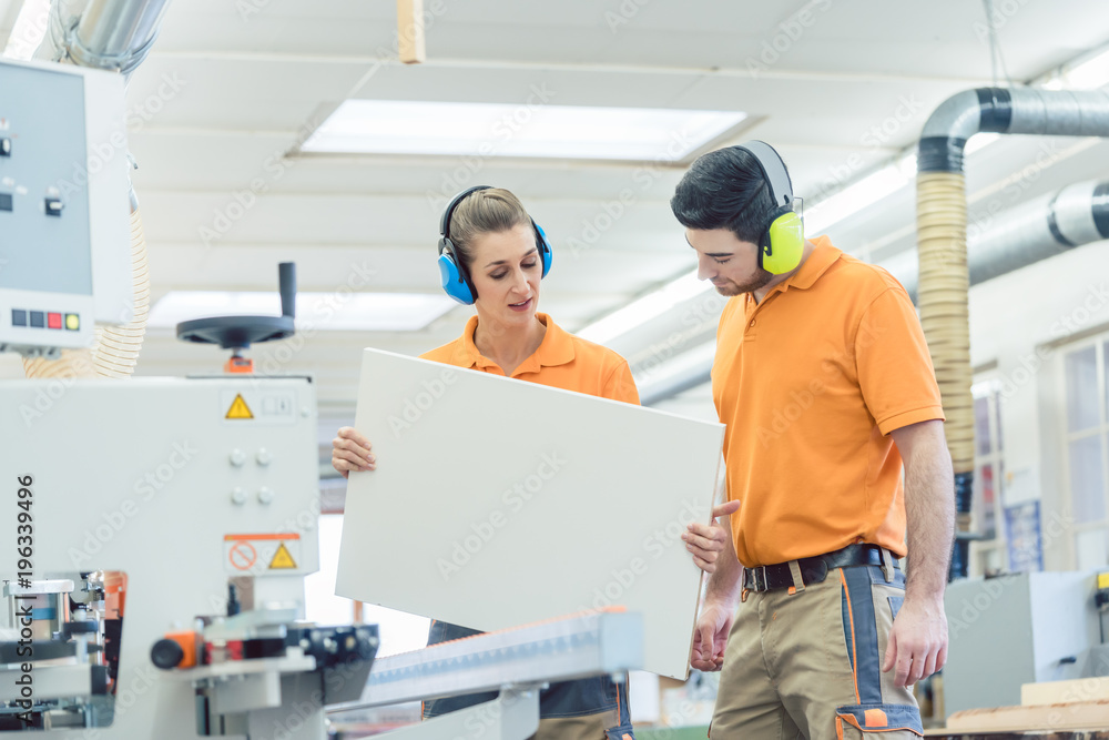 Tischler prüfen bei Qualitätskontrolle ein Werkstück Tischler prüfen bei Qualitätskontrolle ein Werkstück