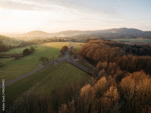 aerial view of beautiful hills with vegetation, trees and road at sunrise, Germany