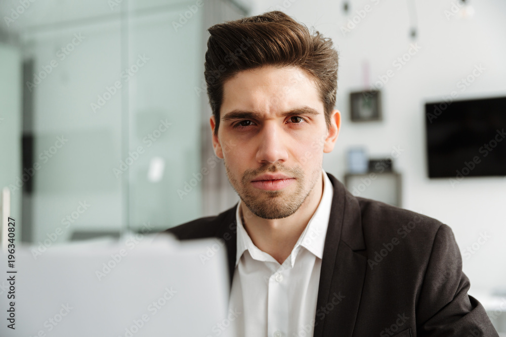Concentrated young businessman working indoors Concentrated young businessman working indoors