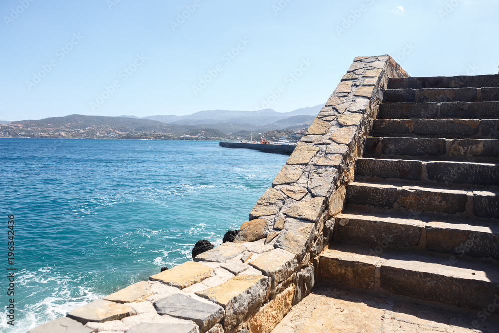Stone staircase to the sea with mountains in the background