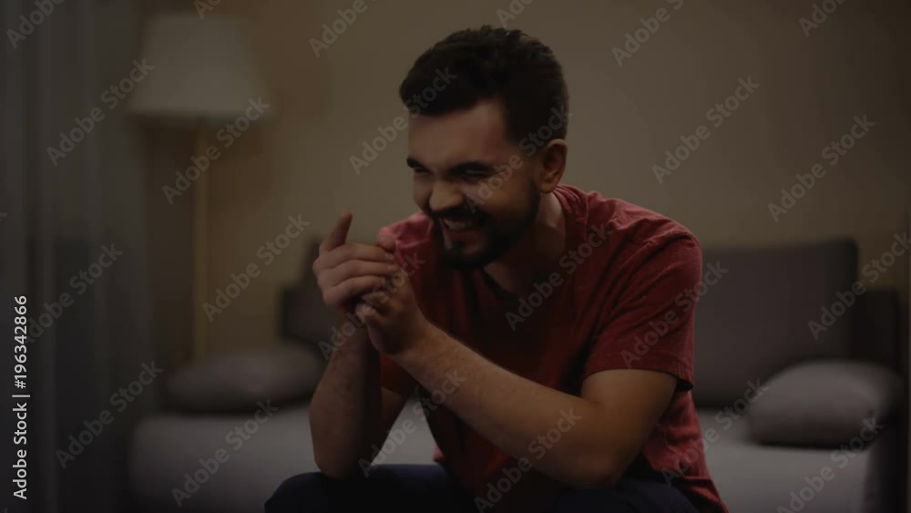 Man watching interesting comedy film at home and laughing, entertainment, hobby Man watching interesting comedy film at home and laughing, entertainment, hobby