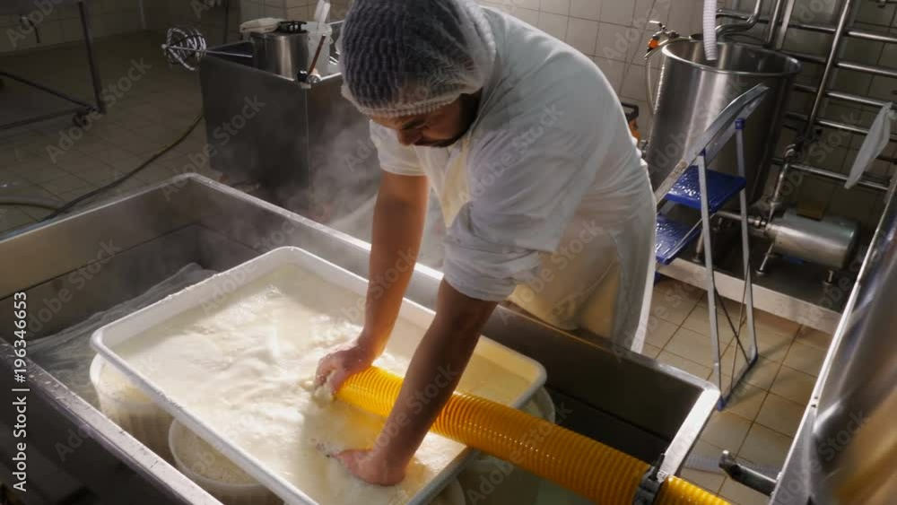 operator works on fresh ricotta cheese- Diary cheese factory operator works on fresh ricotta cheese- Diary cheese factory