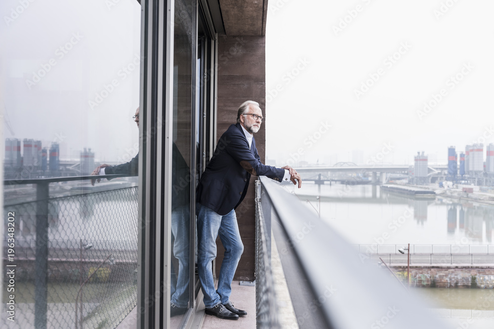 Mature businessman standing on balcony Mature businessman standing on balcony