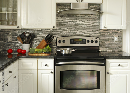 Electric Stainless steel stove, kitchen utensils and vegetables on the cooking table