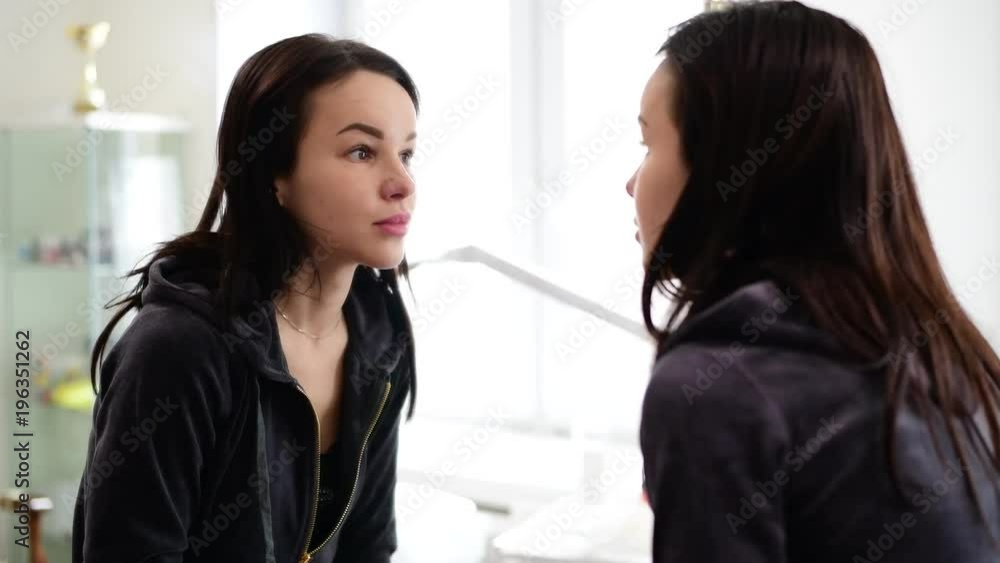 young beautiful girl looks at herself in mirror young beautiful girl looks at herself in mirror