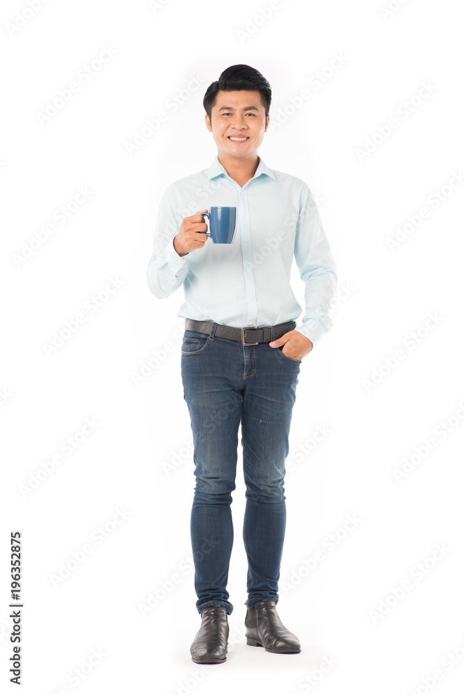 Young Asian man holding mug with hot drink on white background Young Asian man holding mug with hot drink on white background
