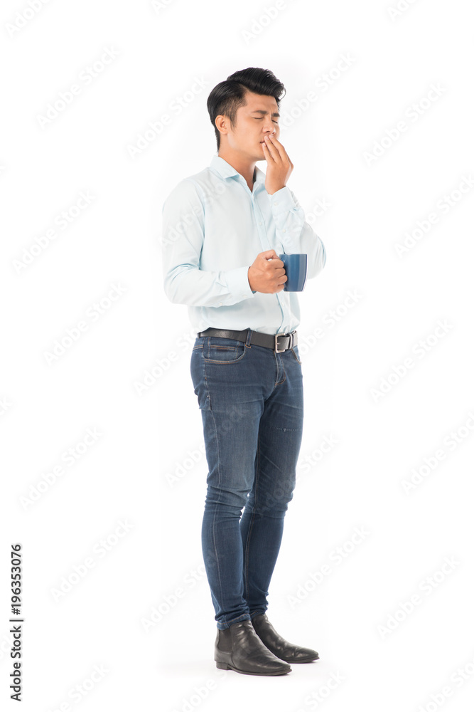 Young Asian man holding mug with hot drink on white background Young Asian man holding mug with hot drink on white background