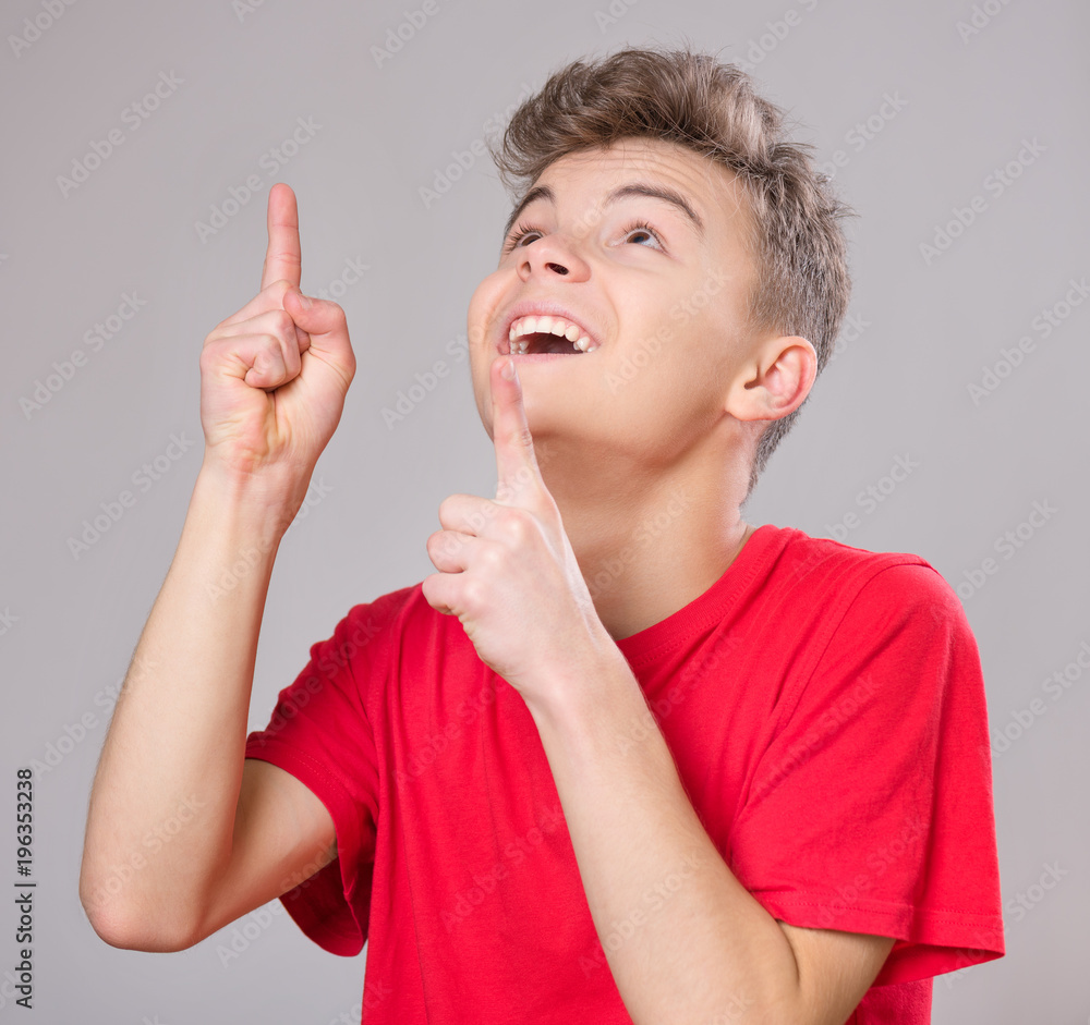 Emotional portrait of excited teen boy. Funny cute surprised child 14 year  old with mouth open in amazement. Happy teenager pointing fingers up, on  gray background. Stock Photo | Adobe Stock
