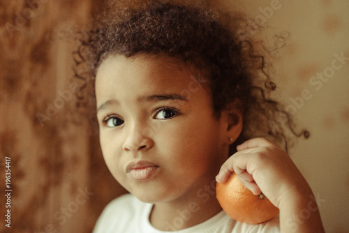 Child with oranges. Happy little girl with fruit.