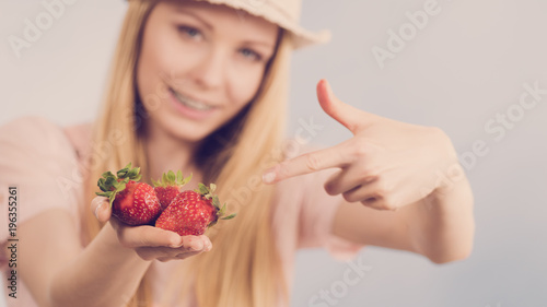 Girl showing fresh strawberries