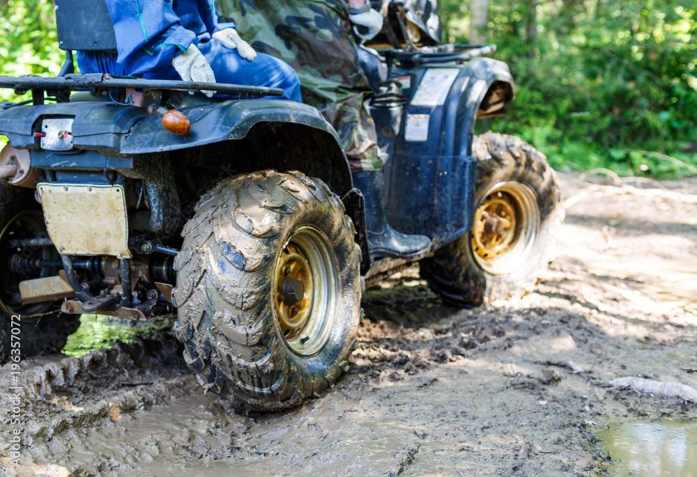 Group of young people riding ATV on dirt track Group of young people riding ATV on dirt track