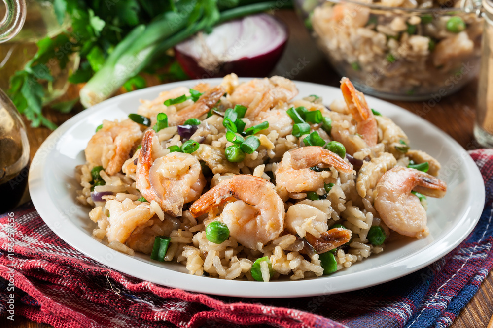 Fried rice with shrimp and vegetables served on a plate Fried rice with shrimp and vegetables served on a plate
