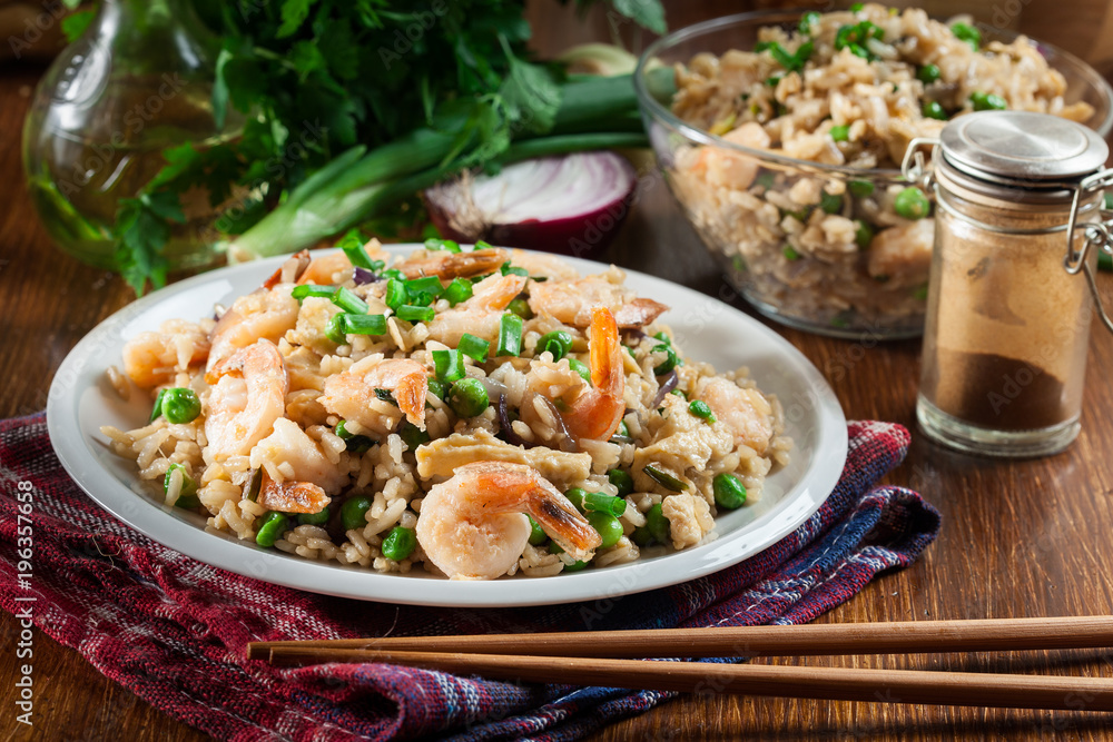 Fried rice with shrimp and vegetables served on a plate Fried rice with shrimp and vegetables served on a plate