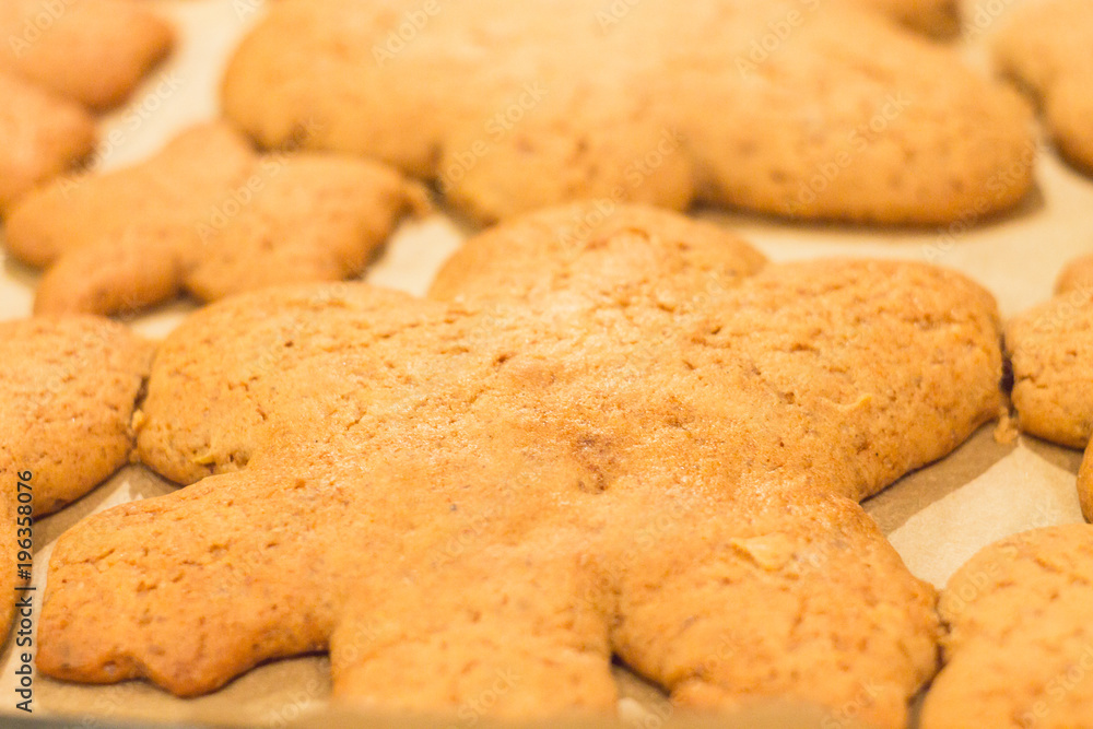 Ginger biscuits lie on a baking sheet. Cookies on baking paper. Selective focus. Ginger biscuits lie on a baking sheet. Cookies on baking paper. Selective focus.