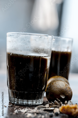 Close up of Asian popular summer drink i.e. Phudina ka shrbat or mint drink with all  its ingredients on a wooden surface which are sugar,mint leaves with its extract,lemon,jaggery and black salt. photo