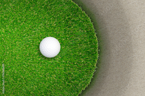 Golf ball on green grass of golf course. Fairway area of green court and sand texture.