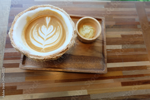 hot latte in coconut on table