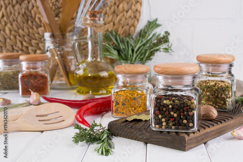 Composition of kitchen tools, spices and herbs on white table