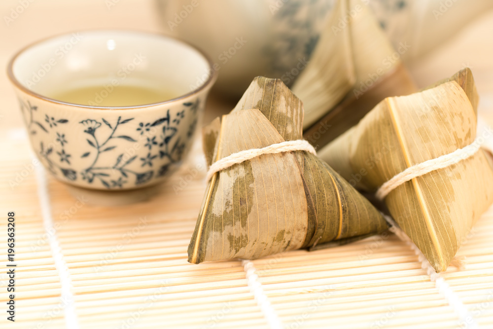 Fototapeta premium Zongzi or Traditional Chinese Sticky Rice Dumplings on Wooden Placemat