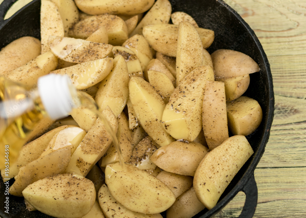 Sliced raw potatoes in a frying pan watered with oil. Sliced raw potatoes in a frying pan watered with oil.