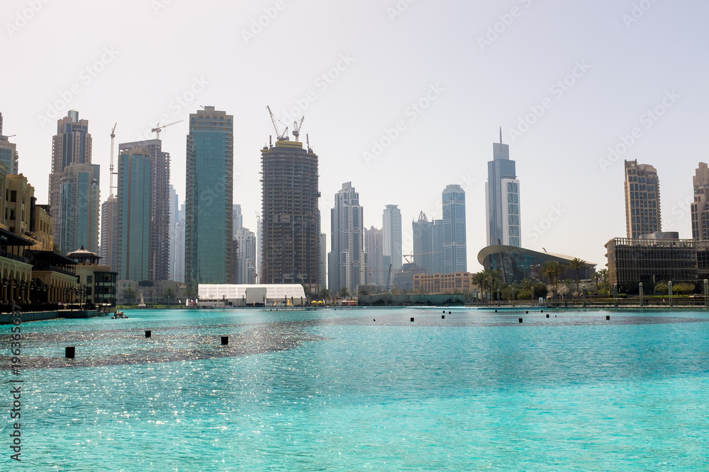Fototapeta premium Cityscape and a large pool in Dubai