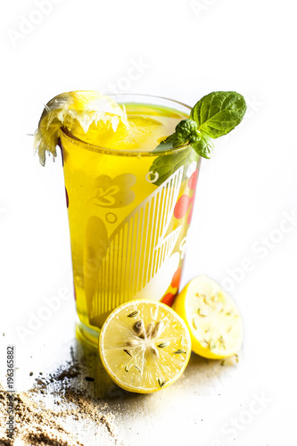 Close up of Indian most popular summer drink Nimbu pani or Nimbo sarbat,Lemonade in a transparent glass with salt and black pepper.Isolated on a white surface. photo