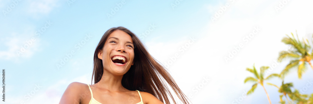 Happy young Asian woman laughing joyful having fun in sun summer outdoor blue sky background panorama banner. Chinese multiracial pretty girl living life. Happy young Asian woman laughing joyful having fun in sun summer outdoor blue sky background panorama banner. Chinese multiracial pretty girl living life.