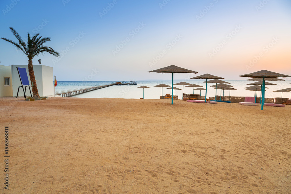 Parasols on the beach of Red Sea in Hurghada at sunrise, Egypt