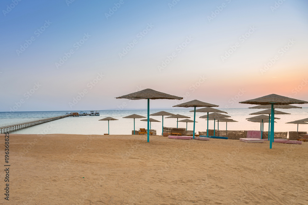 Parasols on the beach of Red Sea in Hurghada at sunrise, Egypt