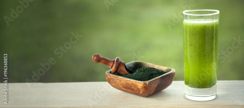 Green smoothie with spirulina on wood background photo