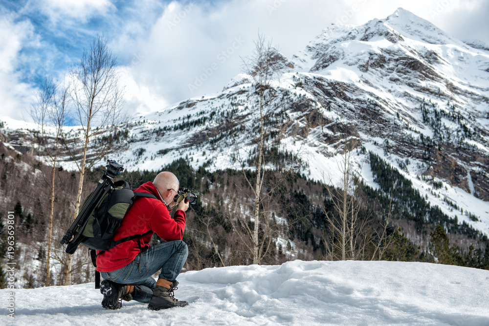 man photographer take  picture in the snowy mountains