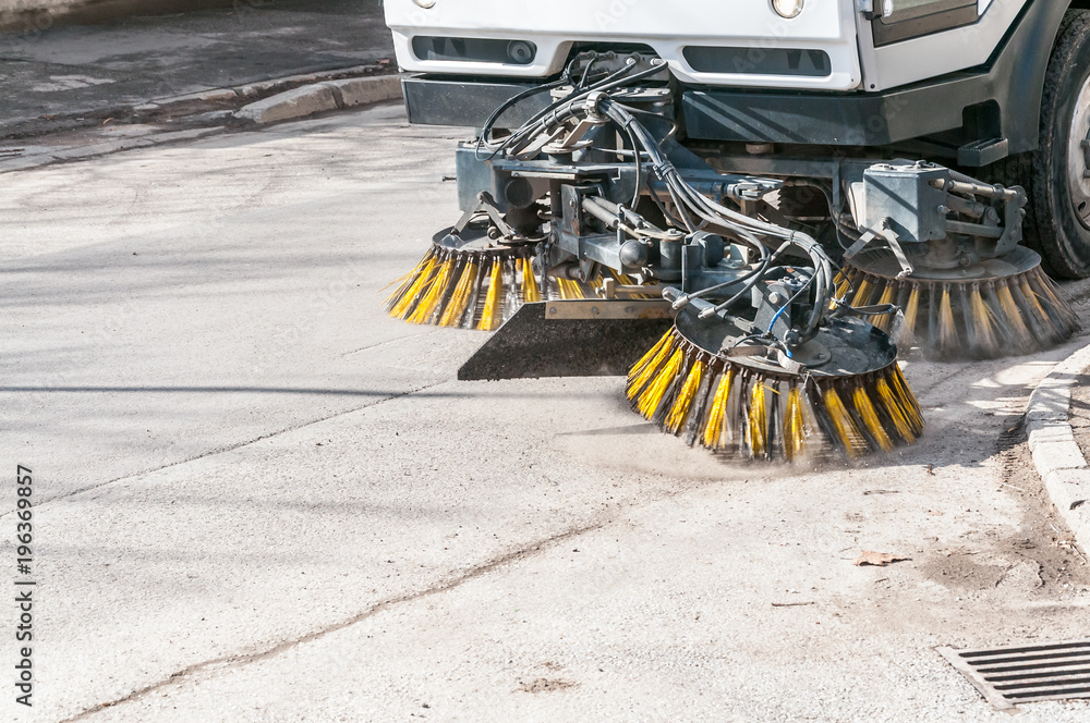 Sweeper machinery. Street sweeper washing garbage and junk from walkway and road with water and cleaning with rotating brushes, motion blur Sweeper machinery. Street sweeper washing garbage and junk from walkway and road with water and cleaning with rotating brushes, motion blur