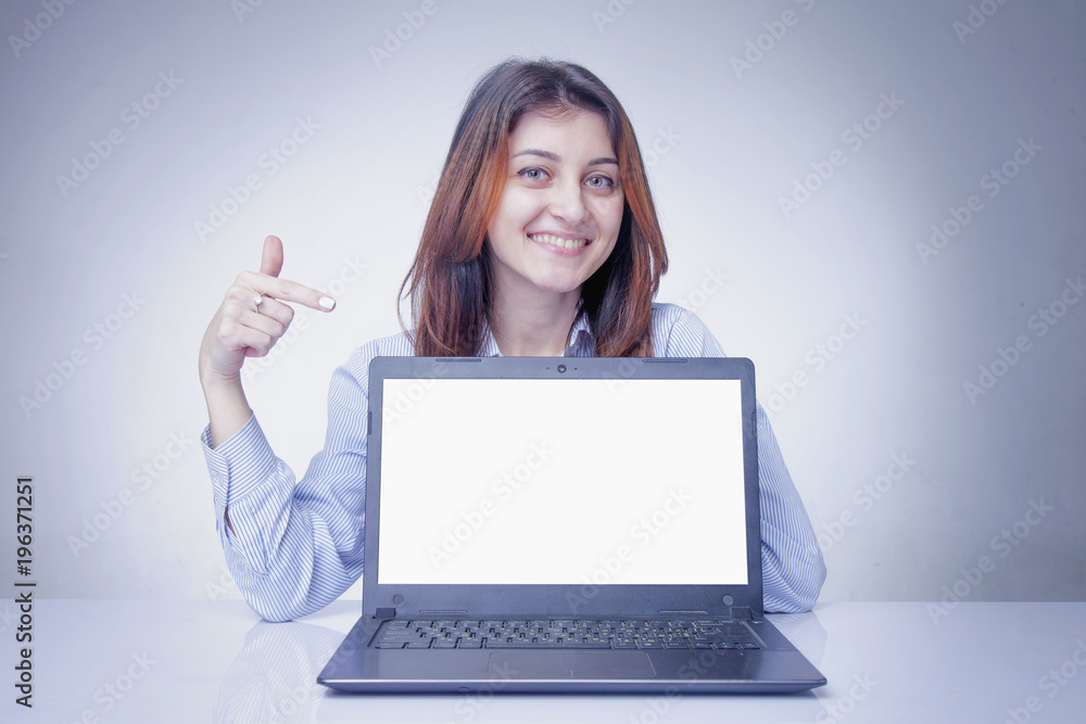 Happy young business woman showing finger on laptop screen Happy young business woman showing finger on laptop screen