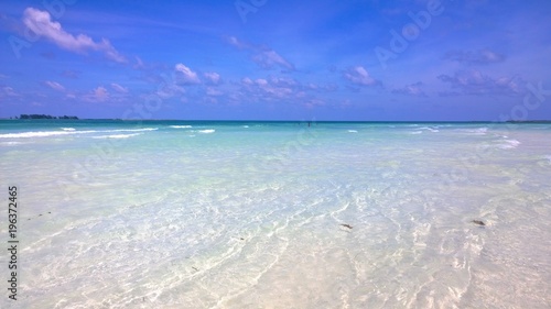 Ocean view of blue sky, beautiful clouds and pacific crystal turquoise water beside a tropical island with powdery white sand . Cayo Guilermo , Cuba 