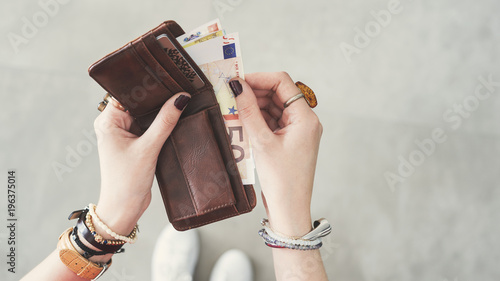 Woman taking out  euro money from her pocket wallet top view photo